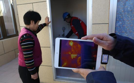 2017年11月14日，顺义区东水泉村，电力工作人员检查煤改电供热设备。摄影/新京报记者 侯少卿