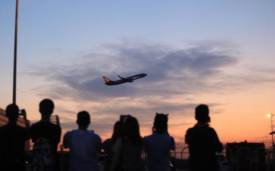 爱好者拍摄飞离的航班。(图源新京报)