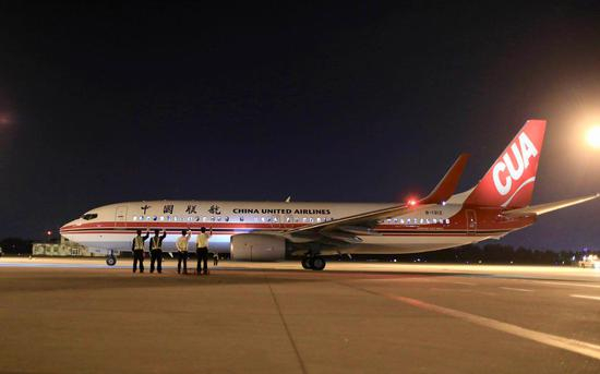 工作人员向最后一班离港航班挥手告别。(图源新京报)