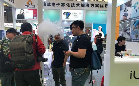 10月30日，几位电子烟玩家在IECIE展上体验大烟雾电子烟。新京报 韩沁珂摄