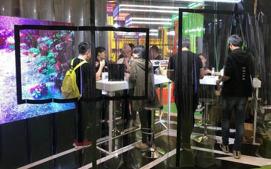 　　10月30日，IECIE展上，VIBE电子烟的展台四周挂满透明的塑料帘幕，营造出一种未来实验室的感觉 . 新京报记者 韩沁珂摄