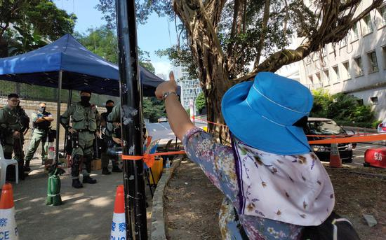 游行途中，市民向路边执勤的警察致敬。 来源：新京报特派香港报道组
