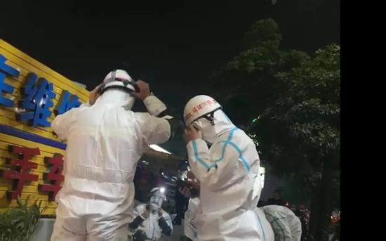 ▲救援人员身穿隔离服进行救援。新京报记者 黄启鹏 摄