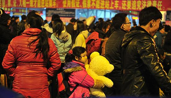 　　2014年1月18日，广东省广州市，春运开始的第三天，夜幕下的广州火车站广场，一位小朋友抱着玩具熊和家人在等候进站。 视觉中国 资料图