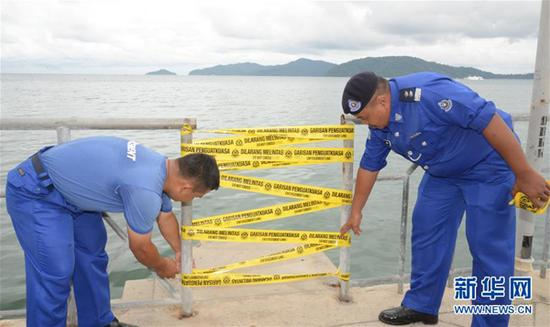 　　2017年2月1日，马来西亚沙巴州哥打基纳巴卢市，执法人员查封载有中国游客的失事船只使用的非法出海码头。新华网 资料图