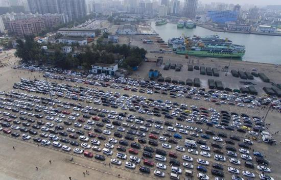 在海口港轮渡码头，准备过海的车辆排队等待登船。