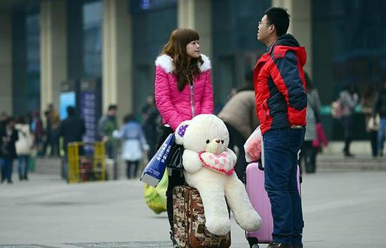 　　2015年2月3日，山东济南火车站，距离春运大幕拉起仅剩一天，各路旅客提前踏上旅途。一对情侣在火车站前惜别，大大的玩具熊上写着“给最爱的你”。 东方IC 资料图