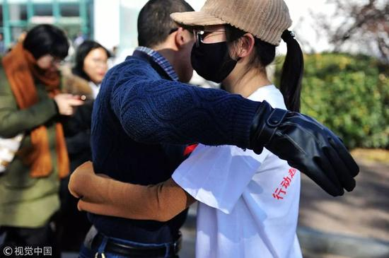 　　2017年12月1日，青岛，中国石油大学（华东），“艾滋病患者”在向行人索求拥抱。图片来自视觉中国