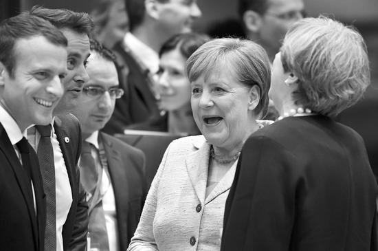  2017年6月22日，法国总统马克龙（左一）同德国总理（右二）、英国首相（右一）等人在布鲁塞尔欧盟峰会上热聊。