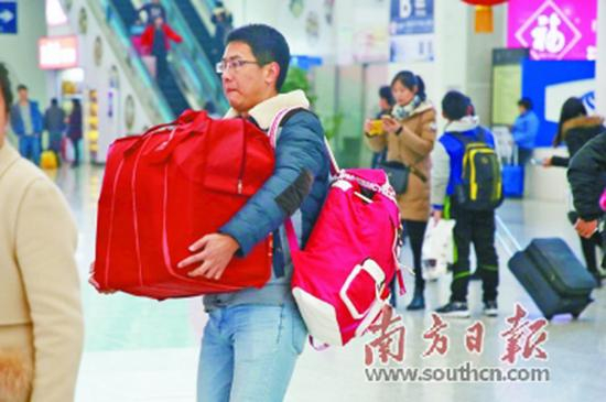 4日，旅客抱着、背着大包小包进站。