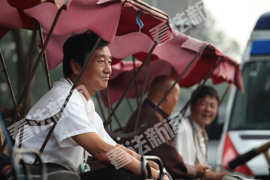 “后海八爷”正坐在三轮车上等候客人 摄/法制晚报·看法新闻 记者 马晓晴