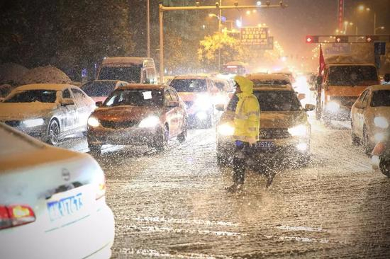 △1月3日，安徽阜阳，交警在雪中执勤。