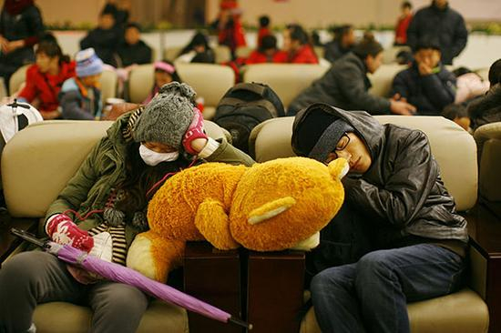 2012年1月15日，武汉，汉口站候车大厅，靠着毛毛熊睡着的年轻人。 视觉中国 资料图