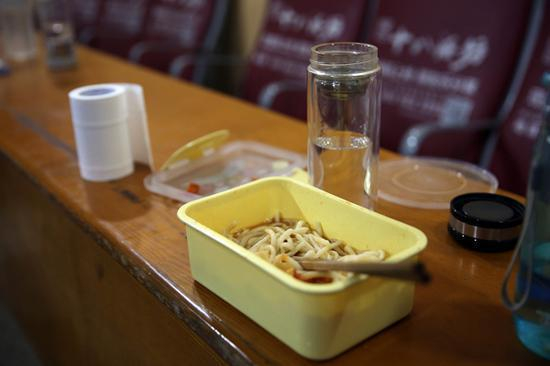 　　当网络订餐的乘客吃上美味又热乎乎的订餐时，配送员回到配送中心坐在座位上，发现自己吃了一半的面条已经凉了，而他已经习惯了。