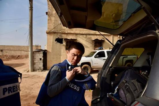 △记者徐德智在战区采访 防弹背心很可能成为危急时刻的救命稻草。