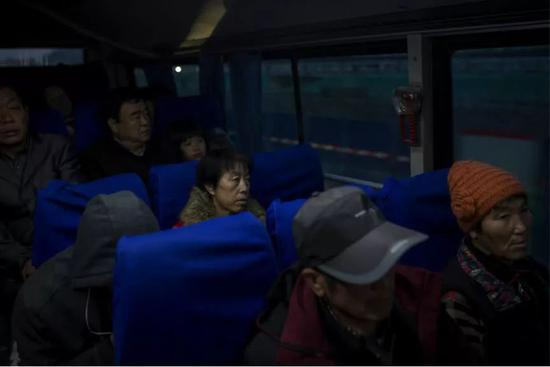 何明英坐上清晨的班车，去赶首班地铁