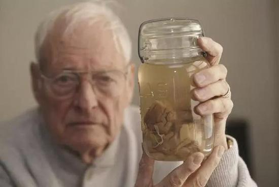 1994年时的哈维，举着一个装有爱因斯坦脑组织的玻璃罐。图片来源：Getty Images