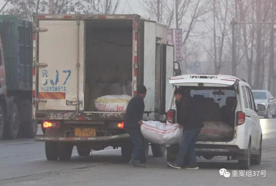 　　▲2017年12月29日，河间时村乡大河路加油站，两名男子从面包车往货车上搬运假驴肉。新京报记者 大路 摄