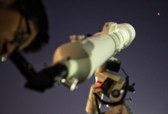 ▲1月31日，北京天文馆，一男士用天文望远镜观看“红月亮”。新京报记者 王嘉宁 摄