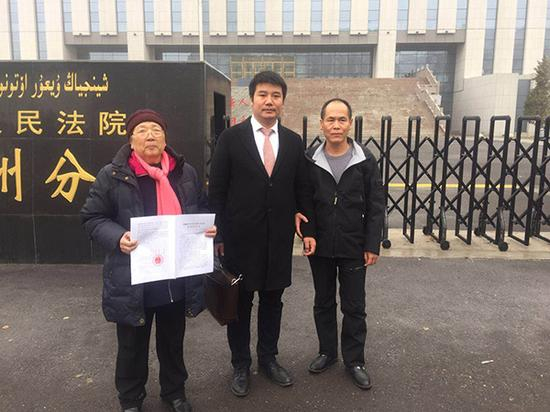 再审宣判后，周远（右），李璧贞（左）和律师在法院前合影。澎湃新闻记者 陈雷柱 图