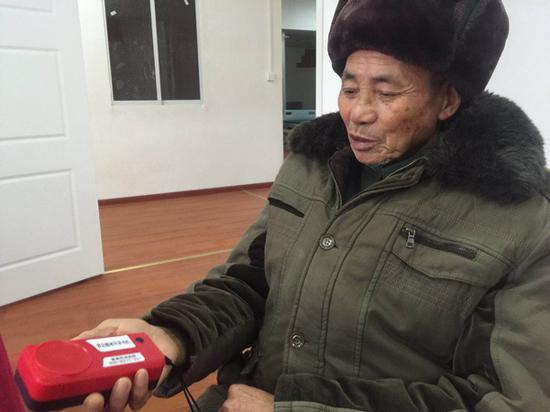 张洪福（化名）拿着评书机。 &nbsp;澎湃新闻记者 陈雷柱 图