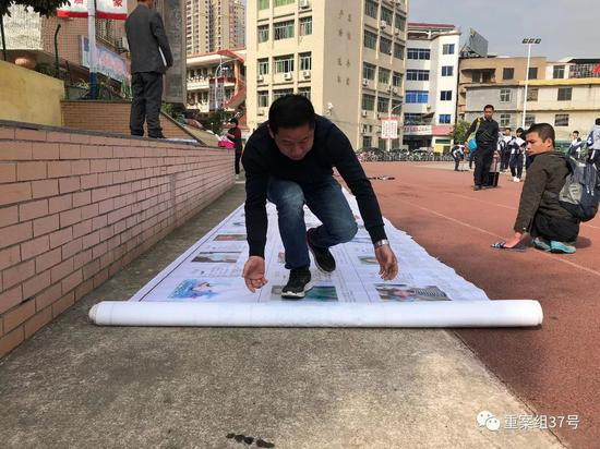 　　▲1月2日中午11时30分，孙海洋和其他十多名寻子家长在紫金县一个中学门口操场上展开写有近百人的寻人启事，他们希望路过的学生和居民都能扩散信息。&nbsp;&nbsp;&nbsp;&nbsp;新京报记者&nbsp;游天燚&nbsp;摄