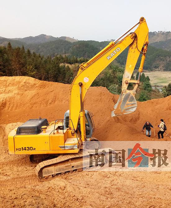 施工方派出挖掘机，协助家属挖堆土山，寻找尸骨。 &nbsp;南国今报 图