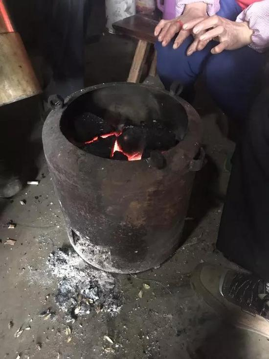 　　12月30日，陈才本夫妇围坐在厨房的火炉前。24日晚，陈家四兄弟在家中烤火取暖时身亡。新京报记者贾世煜 摄