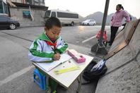 贵阳8岁男孩坐立交桥上写作业
