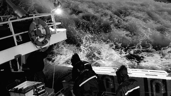 海水倾泄而下，扑向船员。