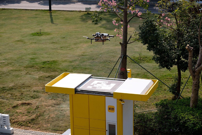 ▲搭载外卖的美团无人机正在专用取货柜顶部降落 （吴用 摄）