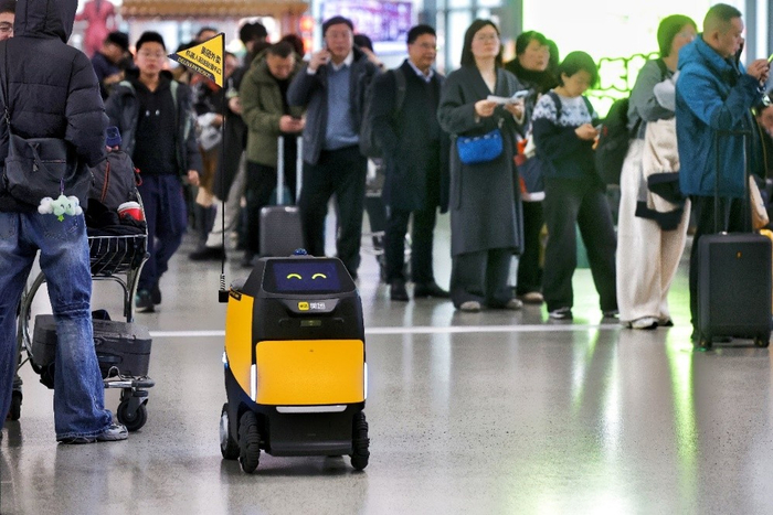 ▲美团“小黄蜂”在人流中穿梭配送外卖（管乐 摄）