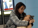 地铁站台里带孩子看手机的母亲