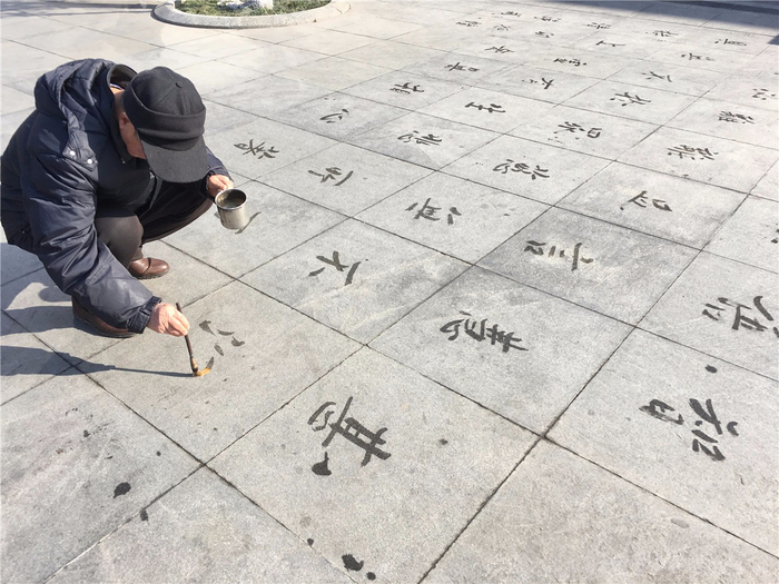 老人扎堆练地书 即使众人围观也如入无人之境