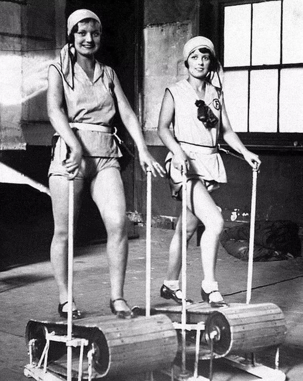 这个器材更为先进，右边的女性使用的器材和现在的腹背训练器差不多。