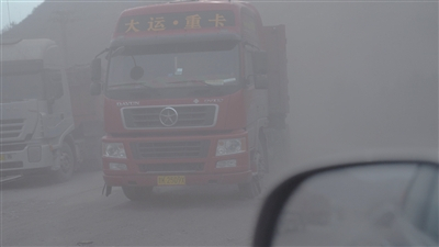 信发铝厂厂区外道路上，大货车来往不断，扬起粉尘。&nbsp; 　　新京报首席记者陈杰&nbsp;摄
