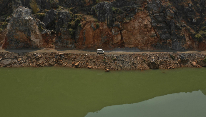 　　载着卯昌富一家5口人的面包车，从大石头组对岸开出，沿着牛栏江边上的砂石路行驶，与大石头组距离渐行渐远。