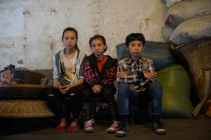 15岁的卯会朵、12岁的卯申文何9岁的卯米会在即将搬离的老房子里合影