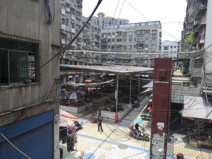 刘金心养母如今的住处在一个菜市场附近的居民楼。新京报记者王双兴摄