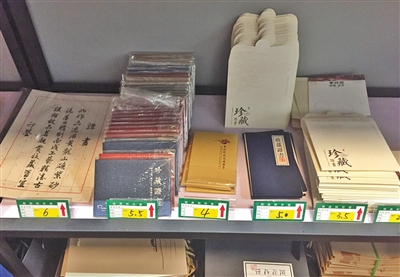 　6月21日，宜兴中国陶都陶瓷城附近一家包装店的货架上种类多样的收藏证书，价格从3.5元到6元不等。