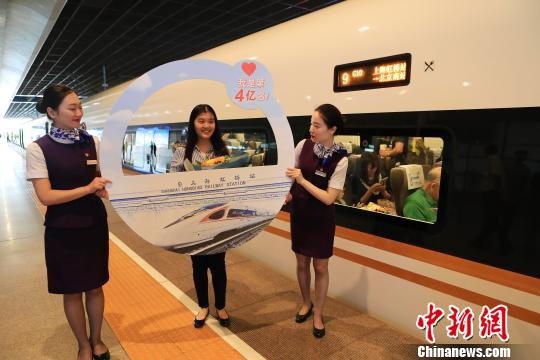 上海虹桥站开站以来的第4亿名旅客沈子怡在复兴号列车前合影留念。　殷立勤 摄
