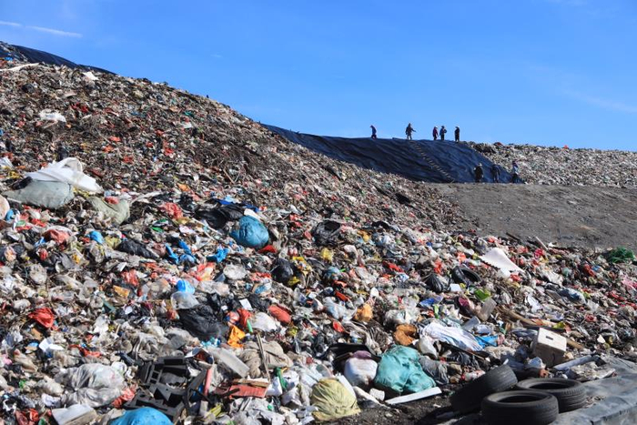  6月19日，海南省澄迈县，垃圾填埋场里堆积的垃圾，不远处工人在进行垃圾填埋的作业。海南澄迈，居民抗议垃圾填埋场，焚烧厂。新京报记者 王嘉宁 摄