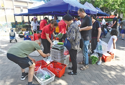 6月22日，新发地菜篮子直通车来到朝阳区华章路小区，周边小区居民前来排队购买。