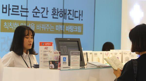 　　资料图片：在韩国首尔一家免税店，中国游客在柜台前付款。越来越多的韩国商家打出支付宝等手机支付的招牌来吸引中国游客。（新华社）