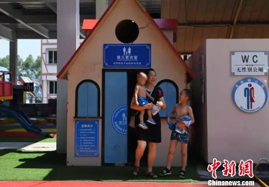  图为一市民带着两个小孩在“第三更衣室”换衣服。陈超 摄