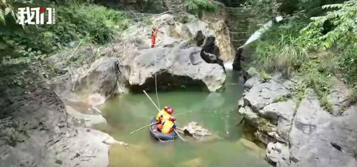 山洪过后，搜救队通过水流湍急的狭窄区域进行救援。 新京报“我们视频”截图