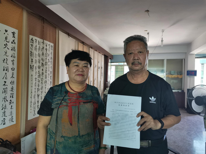 　　2019年7月17日，李成恩、蔡仁英在家中向新京报记者展示判决书，他们所在的房子已被抵押。 新京报记者 韩茹雪 摄