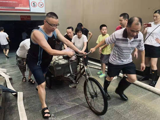 小区居民在运送防洪沙袋。