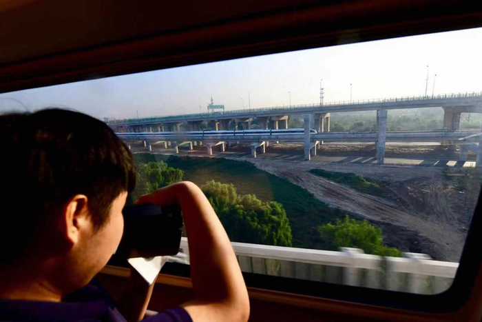 京雄城际铁路乘客在车上俯看大兴机场快轨列车。