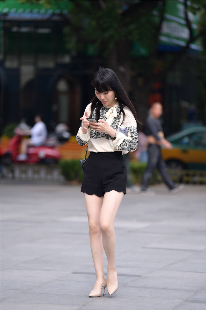 杏色尖头细跟鞋,搭配黑色高腰短裤,白色衬衫上还有刺绣点缀